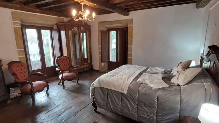 Habitación amplia con cama de matrimonio y butacas en casa rural Cantabria