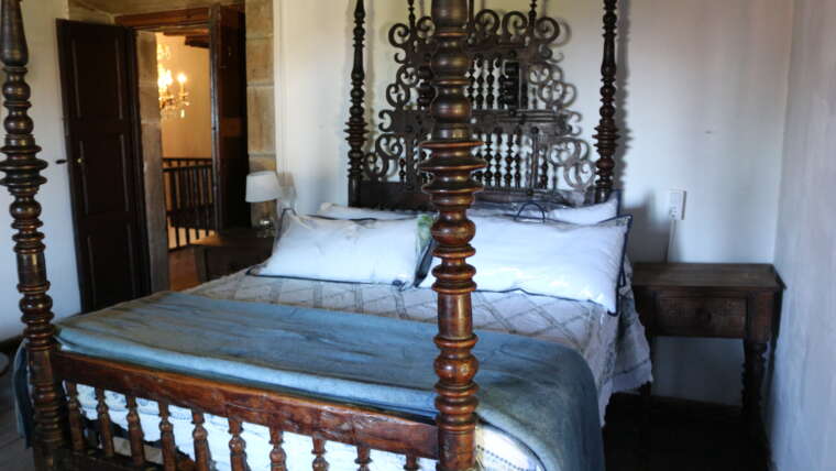 Habitación doble de La Casona de Cabanzón con cama de madera tradicional