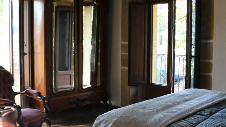 Habitación con balcón y luz natural en La Casona de Cabanzón