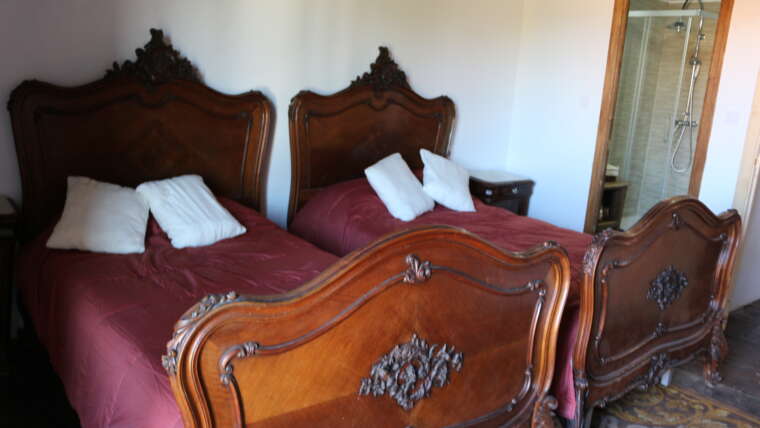 Habitación con dos camas y cabeceros clásicos en La Casona de Cabanzón