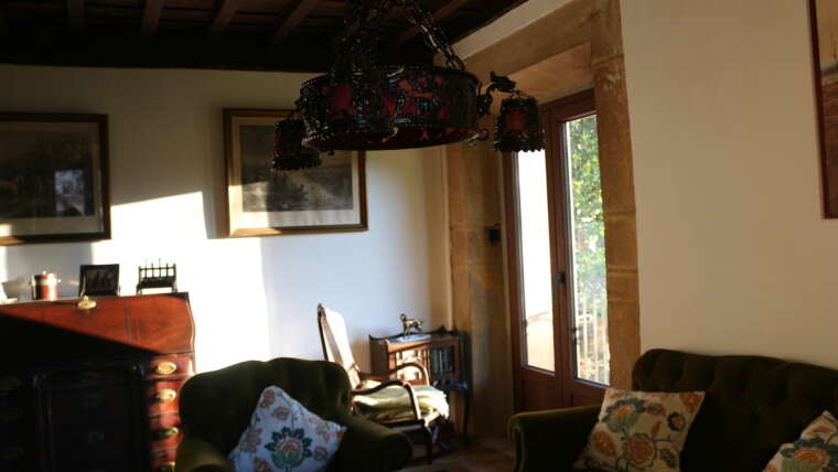 Sala de estar con sofá y balcón en La Casona de Cabanzón
